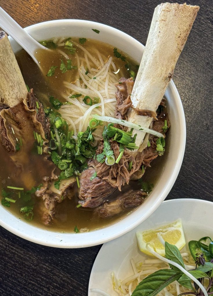 Bone-In Short Rib Noodle Soup has two slabs of bone-in rib meat, rice noodles, and fresh garnishes. Photo credit: Panashe Matemba-Mutasa