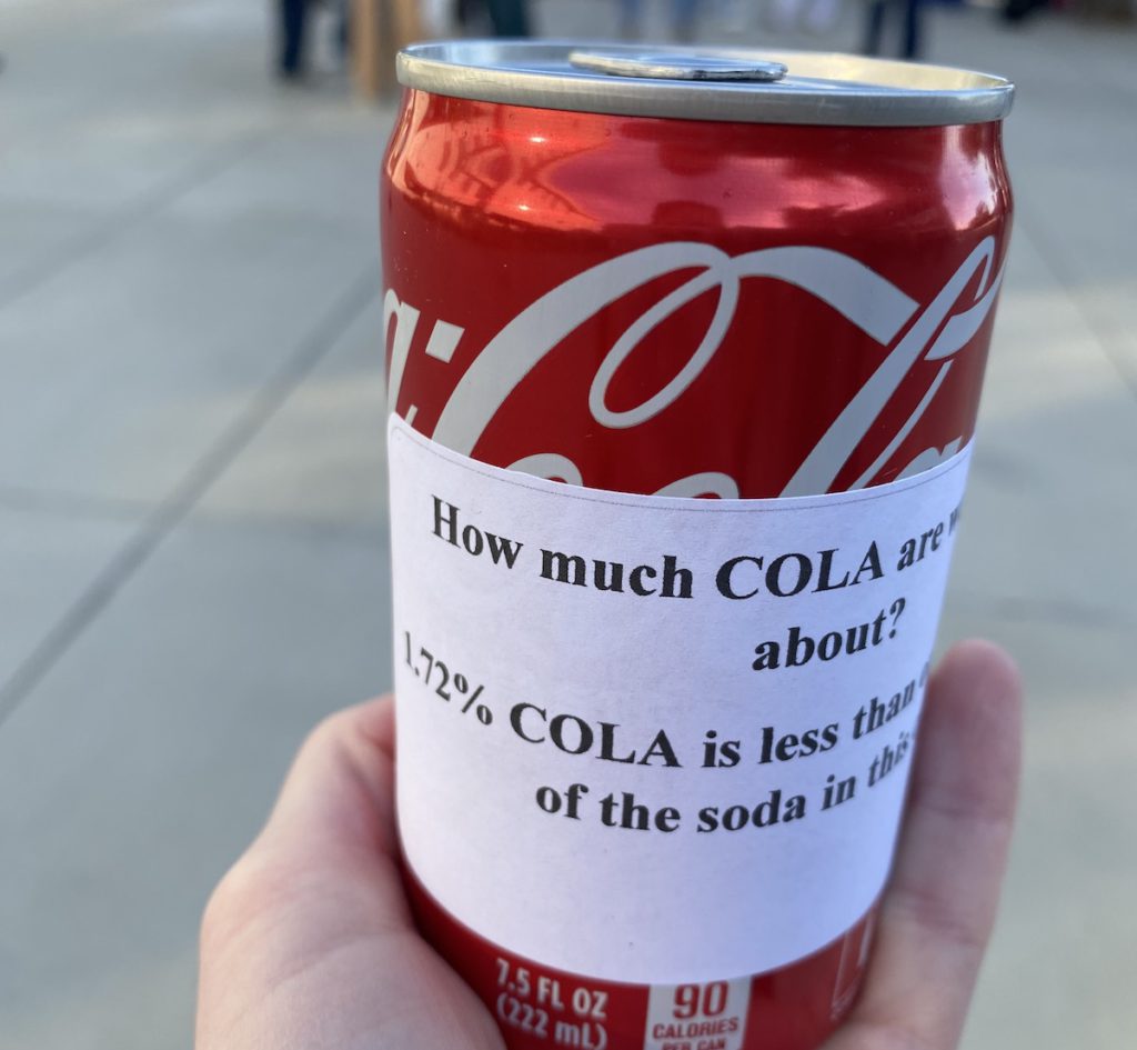 To illustrate what ‘COLA’ means, the teachers union passed out cola cans with the percentage attached to the side. Stephanie Uchida
