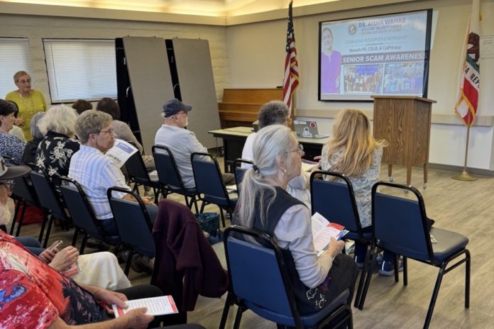 Audience members wait for the Senior Scams presentation to start. Roelle Balan