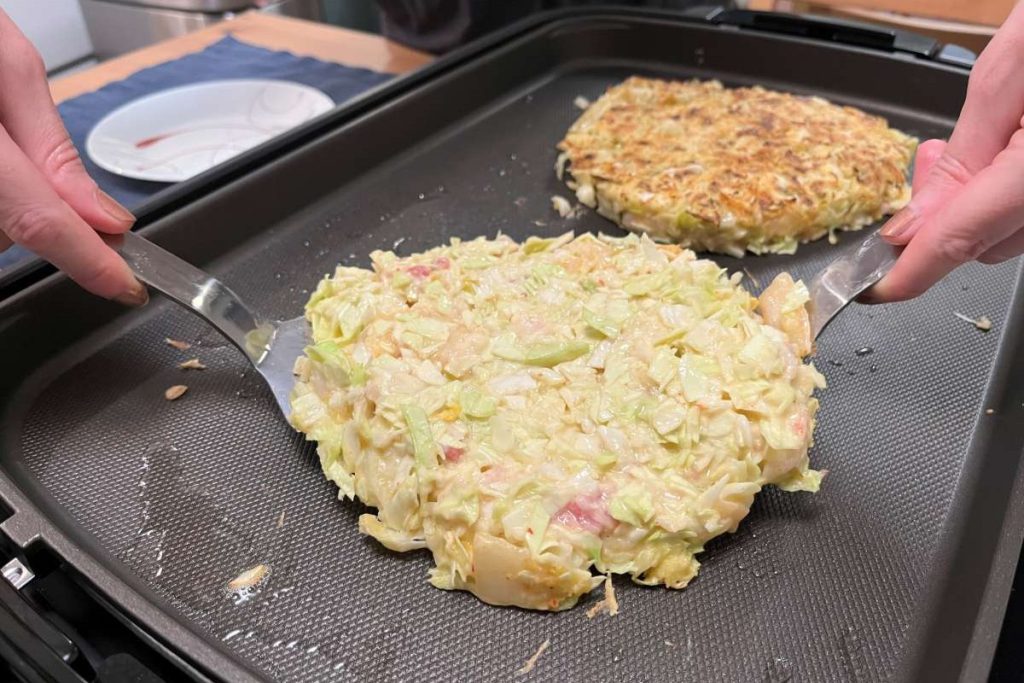 Use two spatulas or one big one to flip okonomiyaki so it can cook on the other side. If it turns into a ‘flop’ just assemble it.
Stephanie Uchida