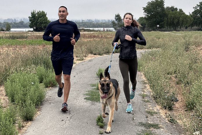 Fremont Police Department employees take a run with a dog during their ‘Flex Hour.’ Photo courtesy of Fremont Police Department