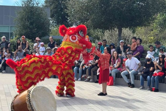 CHOW DOWN Newark City Councilmember Julie Del Catancio holds up a cabbage as the Lion ‘eats’ it. Photos by Roelle Balan