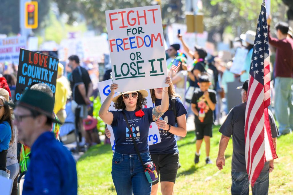 FREEDOM FLAG People came both to protest the decisions of the current administration and to voice their support of democracy.
Photos by Ron Dell’ Aquila